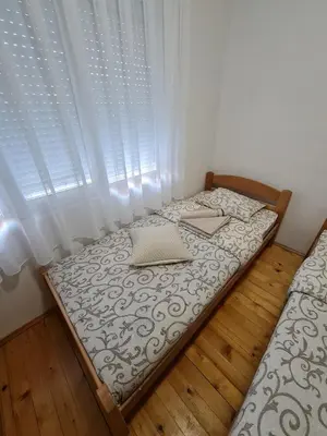 a small bed in a room with a window at Apartment Čolović in Raška