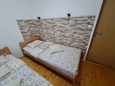 a bedroom with two beds and a brick wall at Apartment Čolović in Raška