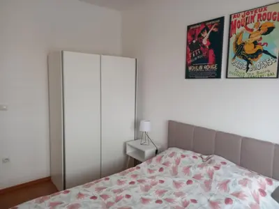 a bedroom with a bed and a poster on the wall at Apartman Marija in Paraćin