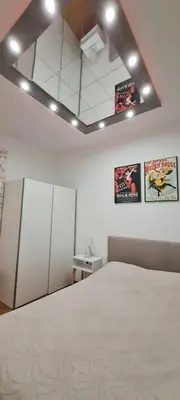 a bedroom with a bed and two posters on the wall at Apartman Marija in Paraćin