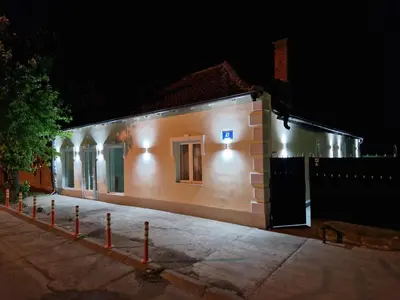 a building with lights on the side of it at night at Apartmani Homoljsko Jutro ☆☆☆☆ Apartments Homolje Morning ☆☆☆☆ in Žagubica