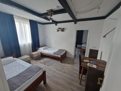 a bedroom with two beds and a desk and a table at Apartmani Homoljsko Jutro ☆☆☆☆ Apartments Homolje Morning ☆☆☆☆ in Žagubica