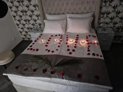a bed with a bunch of red flowers on it at Apartmani Homoljsko Jutro ☆☆☆☆ Apartments Homolje Morning ☆☆☆☆ in Žagubica