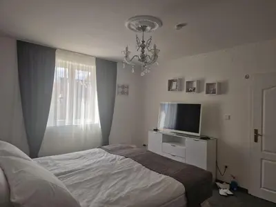 a bedroom with a bed and a tv and a window at Apartmani Homoljsko Jutro ☆☆☆☆ Apartments Homolje Morning ☆☆☆☆ in Žagubica