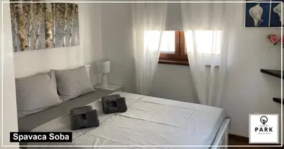 a bedroom with a white bed with two boxes on it at Apartman Park Promenada in Vrnjačka Banja