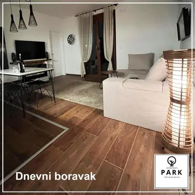a living room with a white couch and a table at Apartman Park Promenada in Vrnjačka Banja