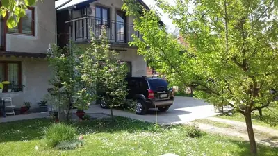 a black suv parked in front of a house at Apartman Jova in Vrnjačka Banja