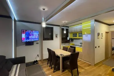 a kitchen and dining room with a table and a tv at Vila Pahulja - Konoba 1 in Kopaonik