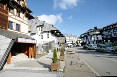 a city street with buildings and cars parked on the street at Vila Pahulja - Konoba 1 in Kopaonik