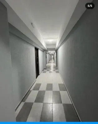 an empty hallway with a checkered floor in a building at De Lux Nedeljkovic in Jagodina