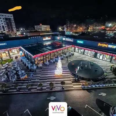 a large building with a fountain in the middle of it at night at De Lux Nedeljkovic in Jagodina