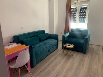 a living room with a green couch and a table at De Lux Nedeljkovic in Jagodina