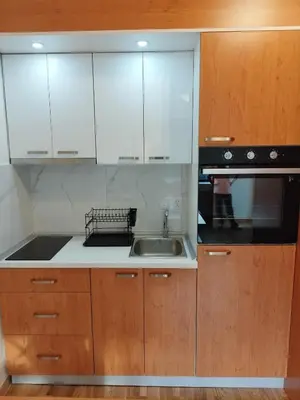 a kitchen with white cabinets and a sink at Apartman Andjelika Vrnjacka Banja in Vrnjačka Banja
