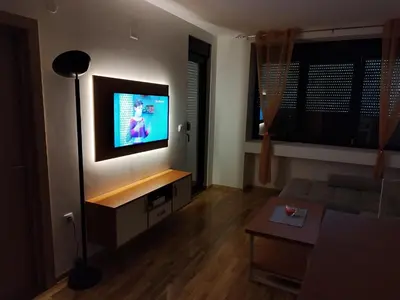 a living room with a flat screen tv on a wall at Apartman Andjelika Vrnjacka Banja in Vrnjačka Banja