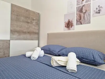 two towels on a bed with blue sheets at Apartman REA 1 in Pirot