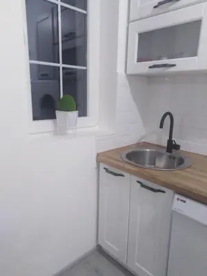 a white kitchen with a sink and a window at Apartman REA 1 in Pirot