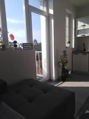 a living room with a couch and a large window at Apartman REA 1 in Pirot