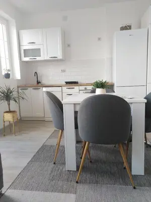 a kitchen with a table and two chairs and a refrigerator at Apartman REA 1 in Pirot