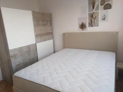 a bedroom with a white mattress in a room at Apartman REA 1 in Pirot
