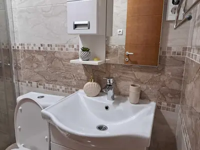 a bathroom with a white sink and a toilet at D&M Porodični apartman in Vrnjačka Banja