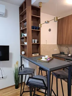 a kitchen with a table and two stools at D&M Porodični apartman in Vrnjačka Banja