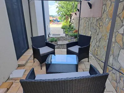 a patio with two chairs and a glass table at D&M Porodični apartman in Vrnjačka Banja