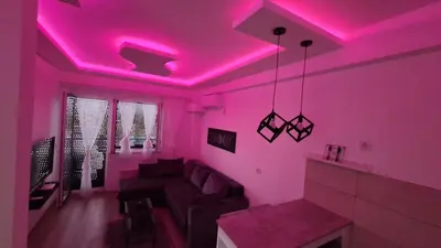 a living room with a couch and a pink ceiling at Aqua Panoramic Apartments in Jagodina