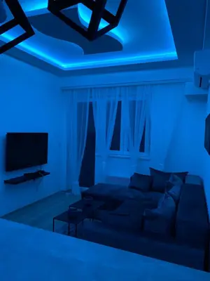 a living room with a couch and a blue light at Aqua Panoramic Apartments in Jagodina