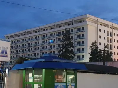 a large building with a blue umbrella in front of it at Aqua Panoramic Apartments in Jagodina