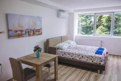 a small bedroom with a bed and a table at RIVERVIEW in Niš