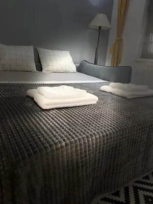 two white towels sitting on top of a bed at Family Home Niš , FREE parking in Niš