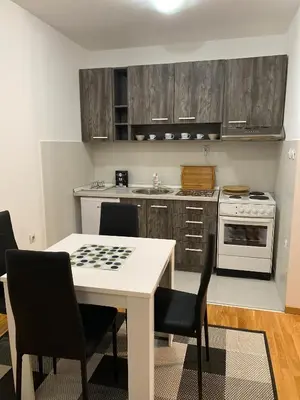 a kitchen with a table and chairs with a checker board on it at Family Home Niš , FREE parking in Niš