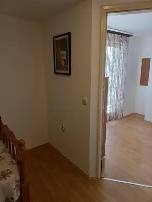 an empty room with a bed and a hallway at Apartman Saša in Vranje