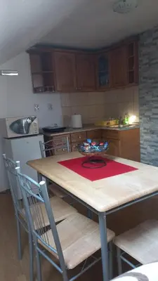 a kitchen with a wooden table with a red rug on it at Apartman Saša in Vranje