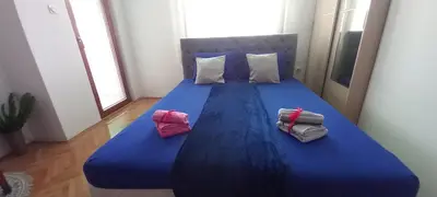 a blue bed with two pillows and two bags on it at Luka Lux in Niš