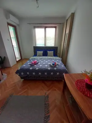 a bedroom with a bed with a blue comforter at Luka Lux in Niš