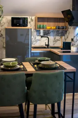 a kitchen with a table and chairs with plates on it at Aqua Casa in Vrnjačka Banja