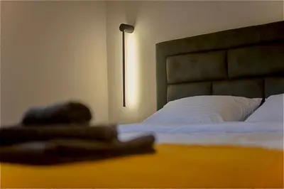 a bedroom with a bed and a lamp on a table at Aqua Casa in Vrnjačka Banja