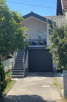 a house with a garage door and a staircase at Aqua Casa in Vrnjačka Banja
