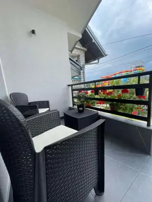 a balcony with wicker chairs and a balcony with flowers at Aqua Casa in Vrnjačka Banja