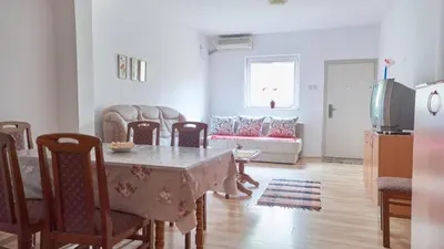 a living room with a table and chairs and a couch at Janković Apartmani u centru in Soko Banja