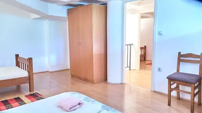 a room with a bed and a chair and a cabinet at Janković Apartmani u centru in Soko Banja