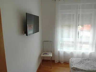 a room with a chair and a television on a wall at Vesna M in Soko Banja