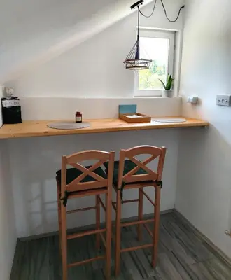 a kitchen with two chairs at a counter with a table at Apartman Boba Vrnjačka Banja in Vrnjačka Banja