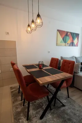 a dining room table and chairs in a room at Petković apartmani 48 in Jagodina