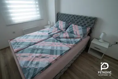 a bed with a quilt on it in a bedroom at Petković apartmani 48 in Jagodina