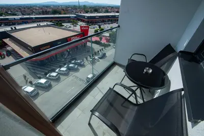 a balcony with a view of a parking lot with cars at Petković apartmani 48 in Jagodina