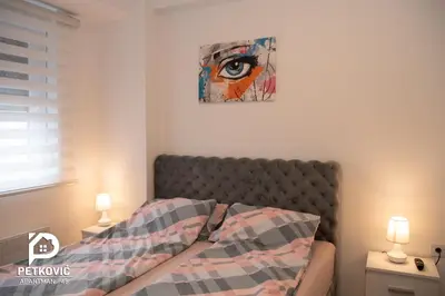 a bedroom with a bed with a painting on the wall at Petković apartmani 48 in Jagodina