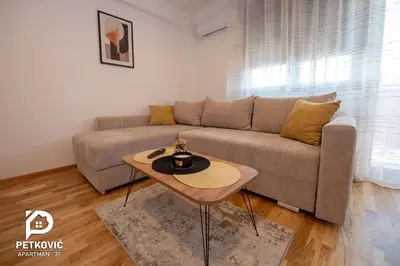 a living room with a couch and a table at Petković apartmani 31 STUDIO in Jagodina
