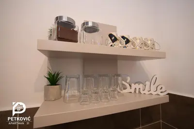 a shelf with glasses on it in a room at Petković apartmani 31 STUDIO in Jagodina